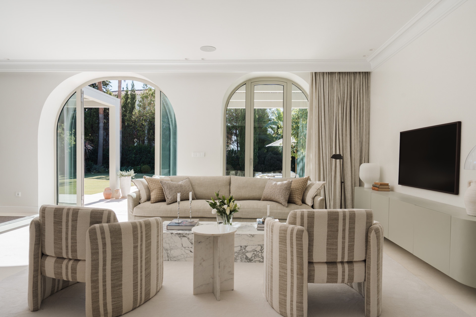 Dining room with arched windows and garden views — Villa Amelie, Nueva Andalucía