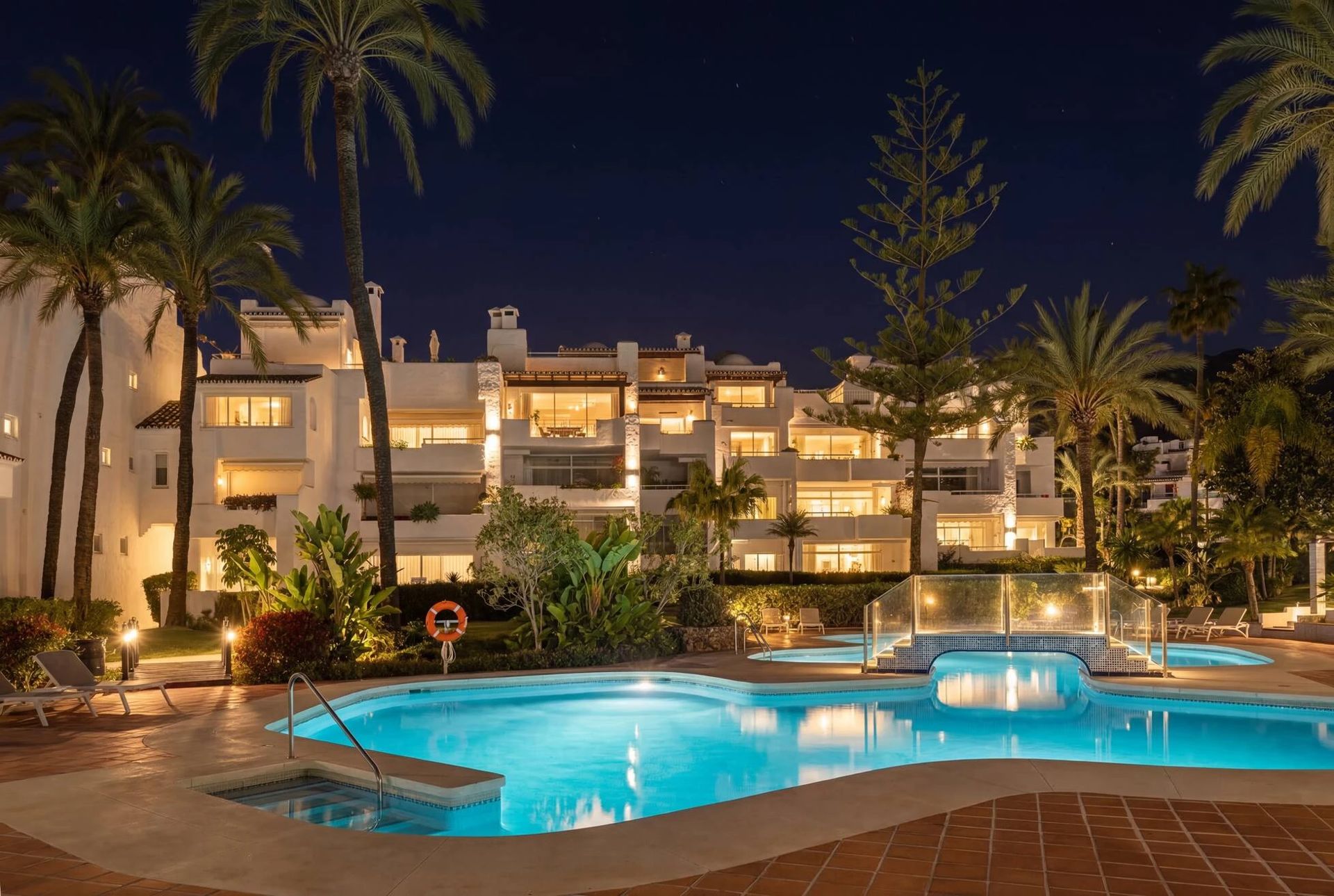 Communal pool and gardens of Alhambra del Mar at night — Golden Mile