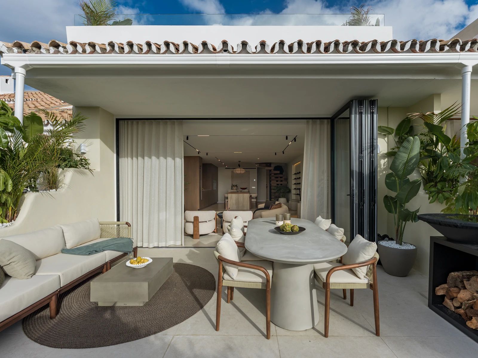 Covered terrace lounge and dining opening onto the living room — Casa Suma, Nueva Andalucía