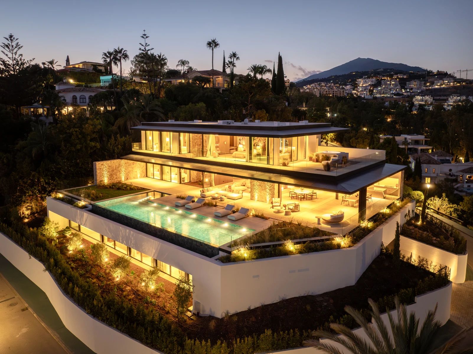 Casa Orquídea illuminated at night, perched atop El Herrojo Alto — La Quinta, Benahavís